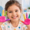 Menina sorridente com mãos coloridas